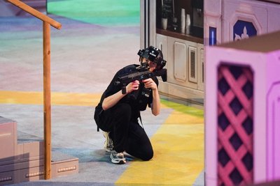 Crouching in black gear behind pink net